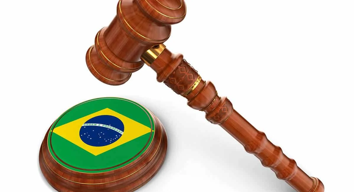 Martelo de juiz batendo sobre bandeira do Brasil