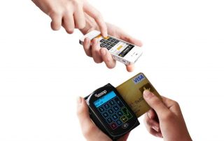 Mãos segurando Zoop Mobile com cartão enquanto outra digita no app do celular