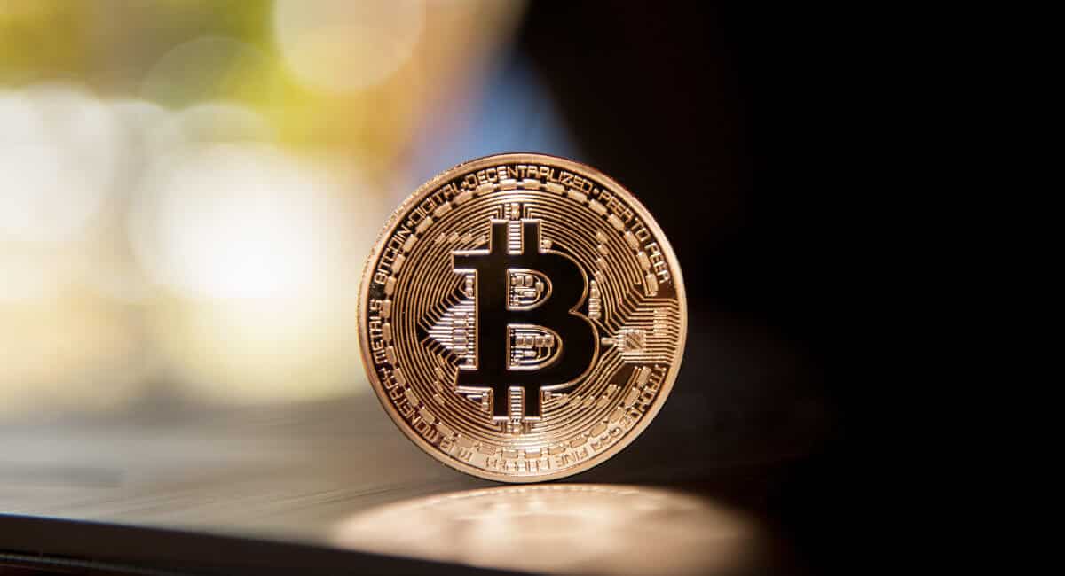Moeda com logomarca Bitcoin de pé