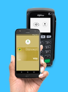 Mão segurando celular fazendo pagamento com Ourocard via Android Pay em máquina de cartão