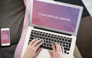 Celular e laptop no colo de mulher sentada em sofá marrom com o texto loja virtual grátis na tela
