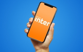 celular mostrando logo do Banco Inter sob fundo azul
