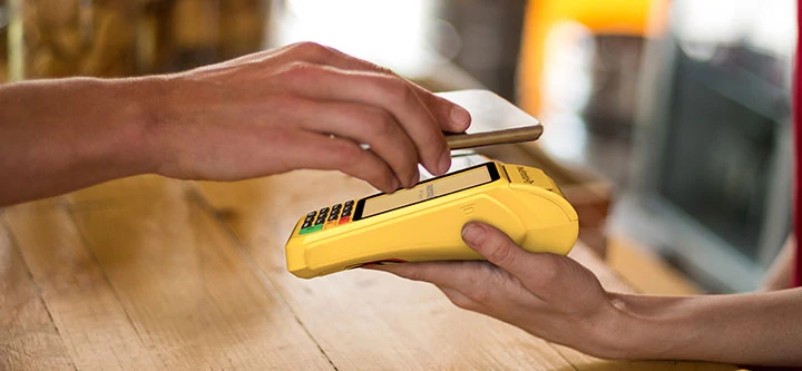 Mão segurando celular para fazer pagamento com a Moderninha Pro