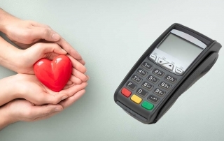 Mãos oferecendo coração ao lado de máquina de cartão