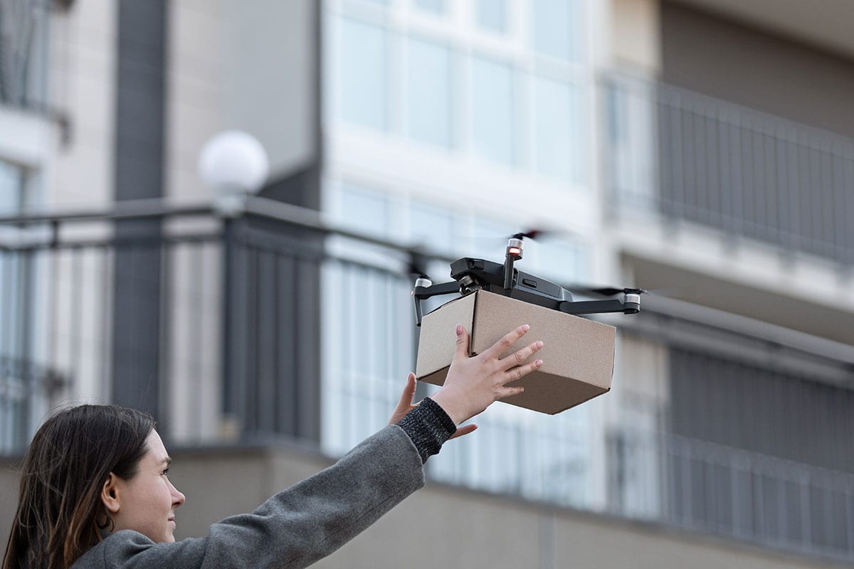Drone fazendo entrega em varanda de prédio