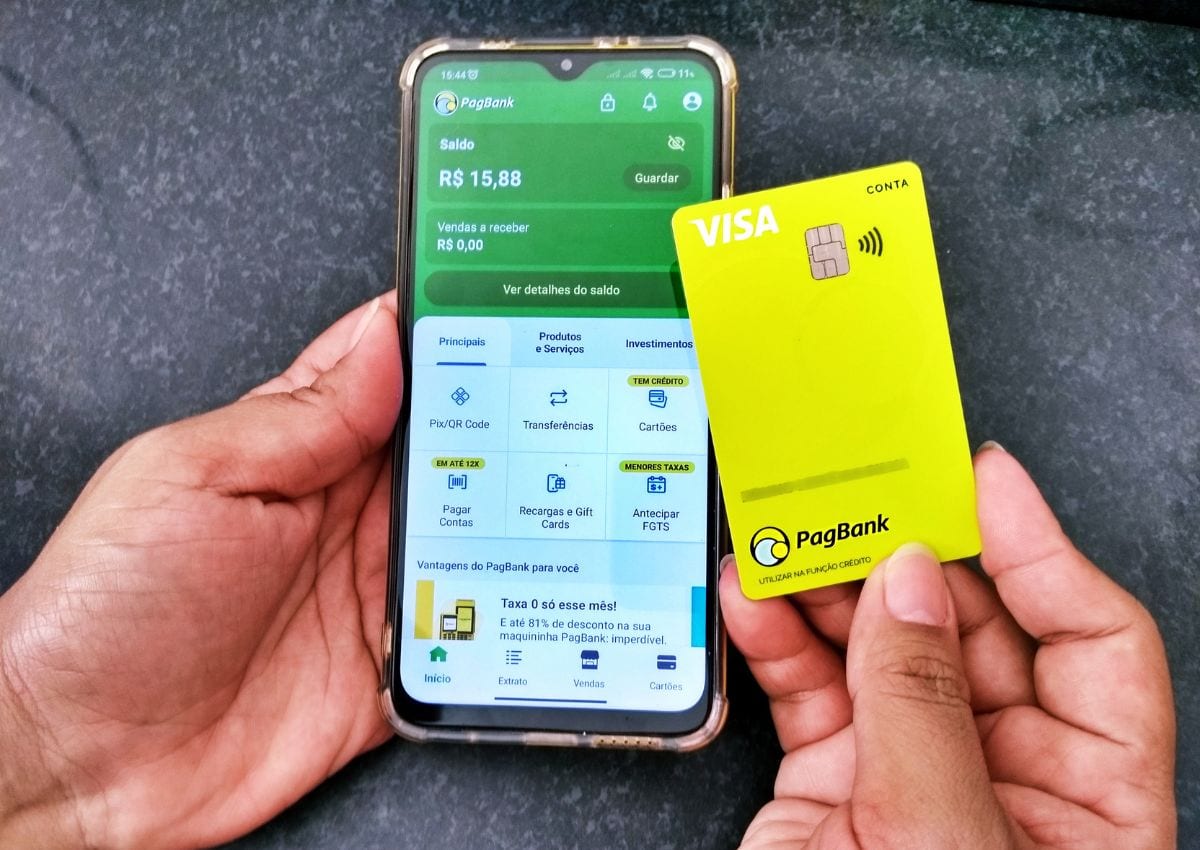 Conta digital PagBank noa tela do celular e cartão na mão
